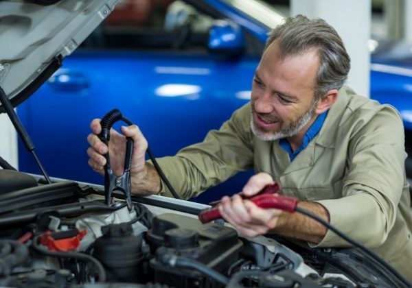 mechanic-attaching-jumper-cables-car-battery_1170-1314