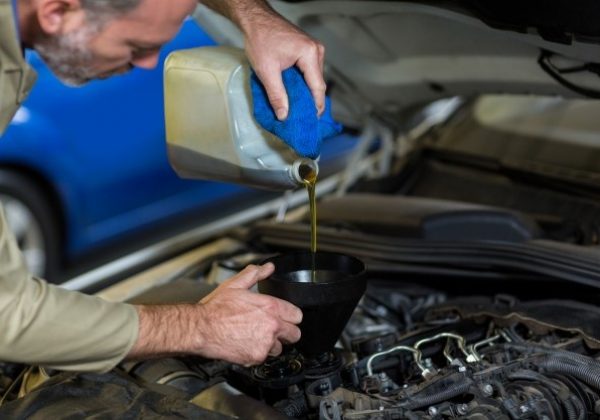mechanic-pouring-oil-into-car-engine_1170-1308